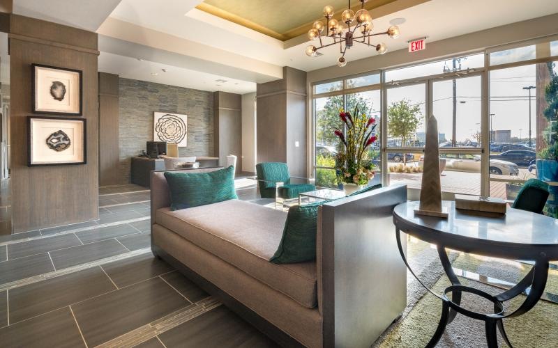 a lobby room with a lounge and large glass door