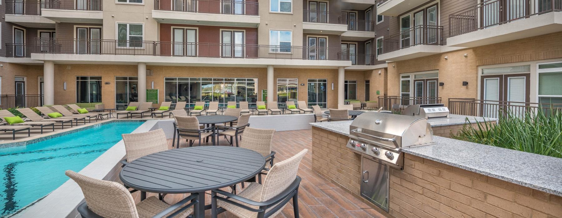 a pool next to chairs on a deck