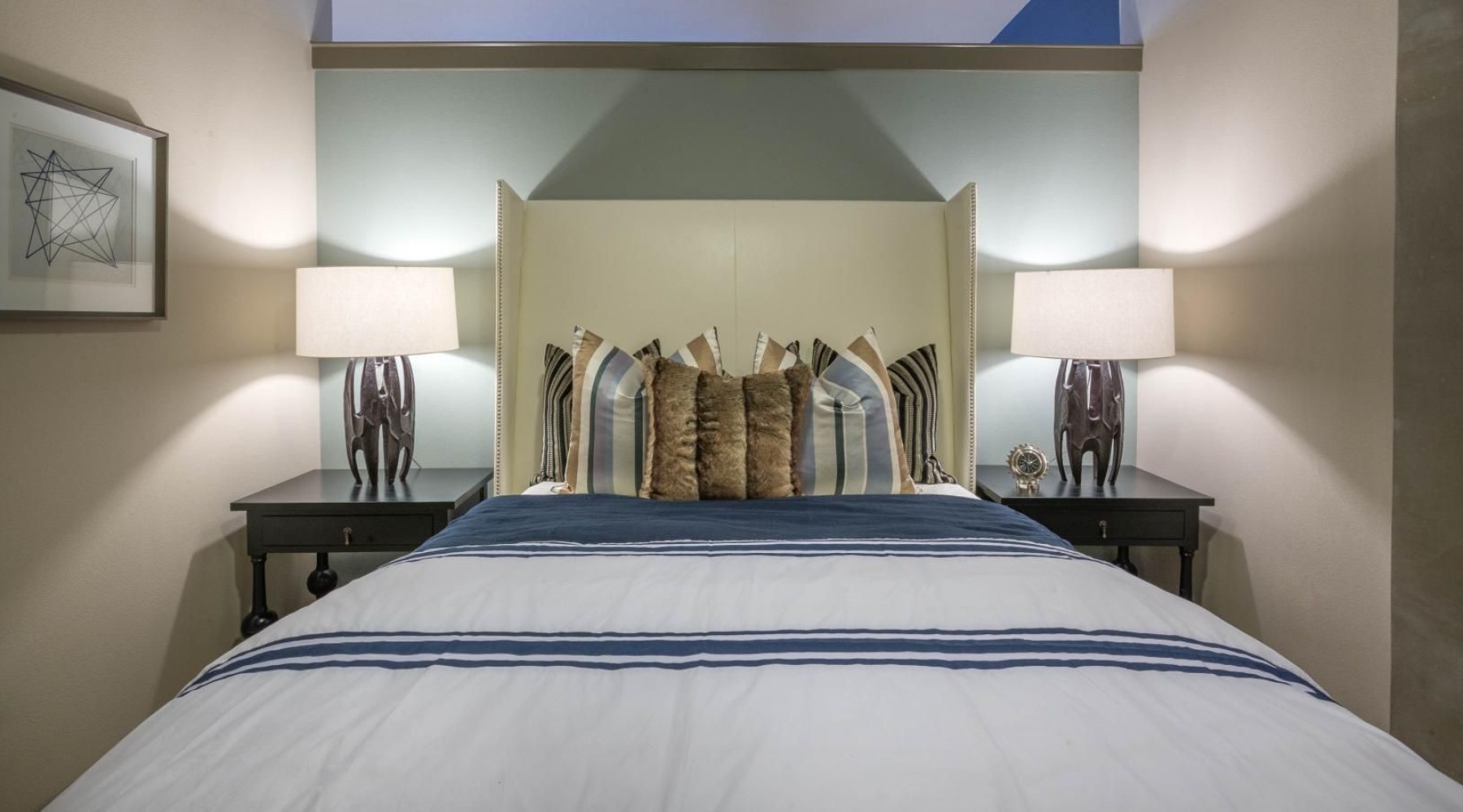 a bedroom with a bed and side tables with lamps