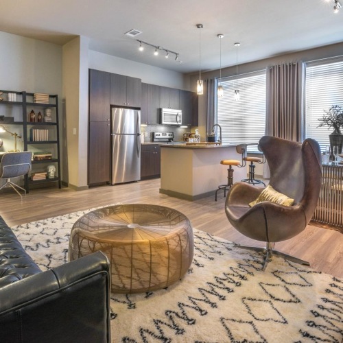 a living room with a large window and kitchen and dining room