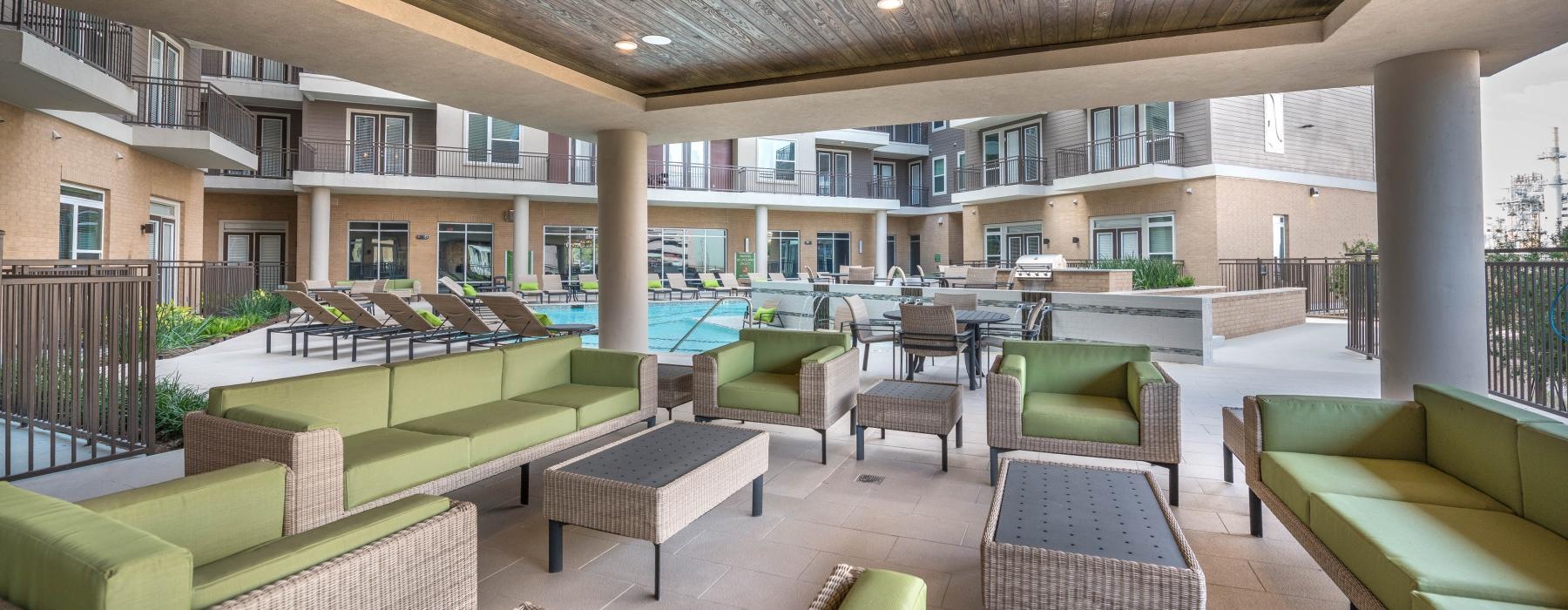 a covered patio by a pool with chairs